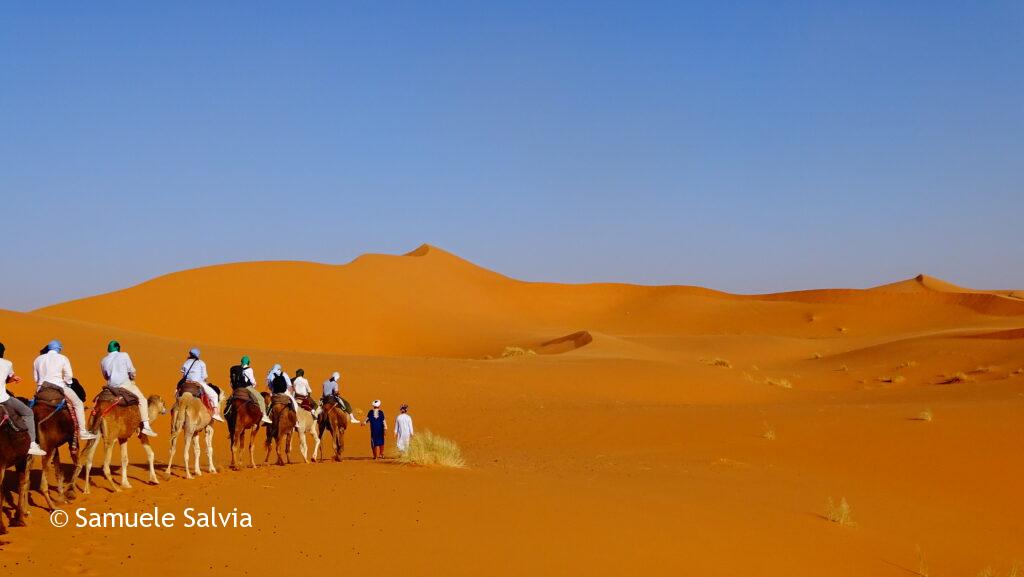 Carovana di turisti nel deserto del Sahara - tra le dune di Merzouga.